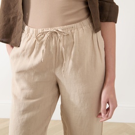 Model wearing Marc O Polo Linen Straight-Leg Trousers in Sandpaper, mid-rise with elasticated drawstring waist, styled with a beige top and brown
