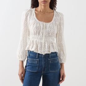 Model wearing Paige Jay Embroidered Blouse in Antique White with square neckline, elasticated waist and ruffled hem, styled with blue jeans.