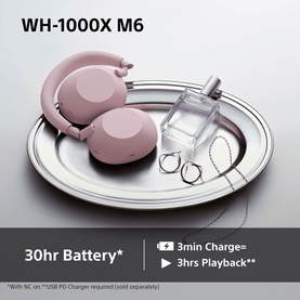 Sony WH1000 Mark 6 Noise Cancelling Bluetooth Over Ear Headphones in pink, shown on silver tray with charging cable
