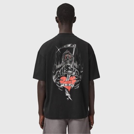 Model wearing All Saints Washed Black oversized T-shirt, back view showing gothic reaper and broken heart graphic print.