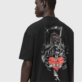Model wearing All Saints washed black oversized T-shirt, back view showing grim reaper graphic print with red heart detail.