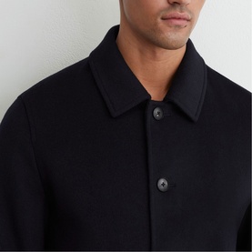 Model wearing Reiss blue wool-blend coat, close-up detail of spread collar and dark button fastening