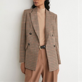 Model wearing Reiss neutral check double-breasted blazer, styled with a beige turtleneck and tailored trousers with a belt.