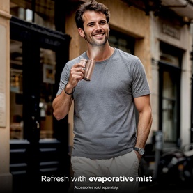 Model with Shark ChillPill 3-in-1 Fan Mist and InstaChill System Iced Latte, holding copper-toned device, wearing grey t-shirt outdoors