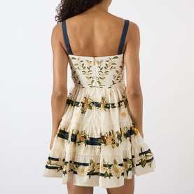 Model wearing Agua Bendita Lima Valle Mini Dress in multicolour floral print, showing back view with navy appliqu&eacute; straps and A-line silhouette.