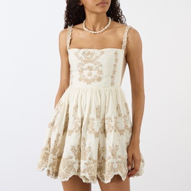 Model wearing Agua Bendita Mielero Cauca Mini Dress in multicolour, cream linen with gold floral embroidery, square neckline and flared skirt