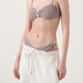 Model wearing Away That Day Cabo Verde Gingham Bikini Bottoms in espresso and ivory gingham, low-rise with gold-tone ring hardware, styled with