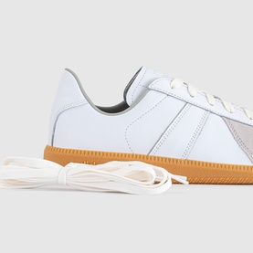Adidas white leather trainer with gum sole, flat white lace detail, side panel stitching, shown with spare laces
