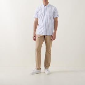 Model wearing Bugatti Stripe Slub Shirt in blue beige, button-down collar, short sleeves, styled with tan chinos and white trainers.