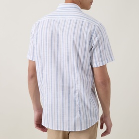 Model wearing Bugatti Stripe Slub Shirt in blue beige, rear view showing short sleeves, stripe pattern, and curved hemline.