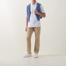 Model wearing Bugatti Stripe Slub Shirt in blue beige, short sleeves, styled with tan chinos and white trainers, blue jumper over shoulders.