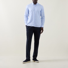 Model wearing Bugatti Soft Oxford Shirt in blue stripe with navy chinos and navy suede trainers.