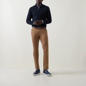 Model wearing Bugatti Navy Cotton Half Zip, styled with tan slim-fit trousers, brown belt, and navy trainers.