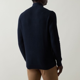 Model wearing Bugatti navy cotton half zip knit, shown from the back with ribbed texture detail, styled with tan trousers