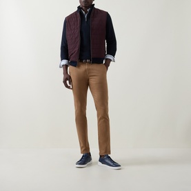 Model wearing Bugatti Navy Cotton Half Zip, styled with burgundy quilted gilet, tan chinos and navy trainers.