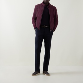 Model wearing Bugatti Black Berry quilted zip-through jacket, styled with navy trousers, black roll-neck and brown suede shoes.