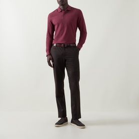Model wearing Bugatti blackberry long-sleeve cotton polo, styled with dark trousers and a brown leather belt.