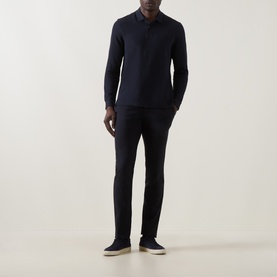 Model wearing Bugatti Logo Polo Shirt in navy, long sleeves, ribbed cuffs, styled with dark trousers and white slip-on shoes.