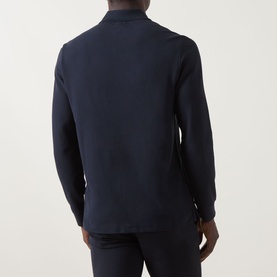 Model wearing Bugatti Logo Polo Shirt in navy, rear view, long sleeves with ribbed cuffs, paired with navy trousers.