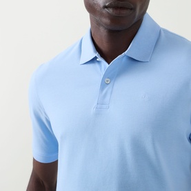 Model wearing Bugatti light blue polo shirt, close-up showing classic collar, two-button placket and small chest logo embroidery.