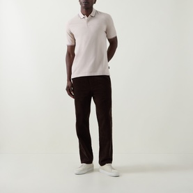 Model wearing Bugatti beige cotton polo shirt with dark brown trousers and white trainers.