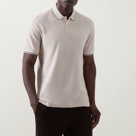 Model wearing Bugatti beige cotton polo shirt with contrast tipped collar and cuffs, styled with dark trousers