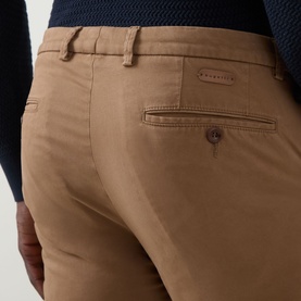 Model wearing Bugatti brass chino trousers, close-up of rear pocket and waistband detail, slim fit cotton blend