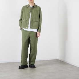 Model wearing Emporium 89 Ripstop Logo Jacket in green with matching green trousers and black chunky loafers.