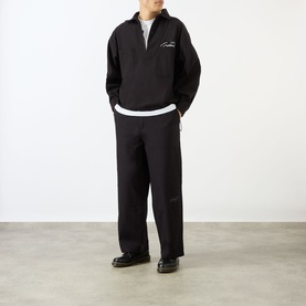 Model wearing Emporium Ripstop Fatigue Wide Leg Denim Trousers in black, styled with a black half-zip sweatshirt and black shoes.