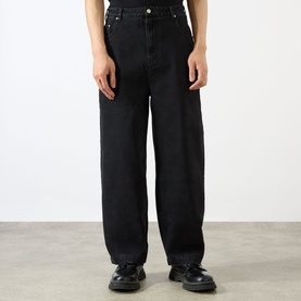 Model wearing Emporium Stitch Wide Leg Jeans in black, wide-leg fit, five-pocket style, styled with black chunky loafers.