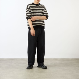 Model wearing Emporium Stitch Wide Leg Jeans in black, wide-leg fit, styled with a striped knit sweater and black leather shoes.