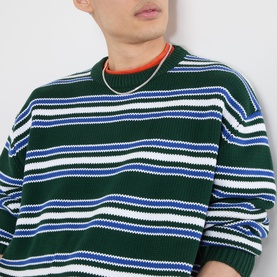 Model wearing Emporium Stripe Fisherman Knit Sweater in green with blue and white stripes, crew neck, styled with gold chain necklace.