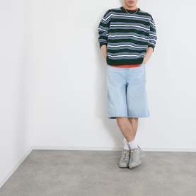 Model wearing Emporium Stripe Fisherman Knit Sweater in green, styled with light blue denim shorts and grey chunky trainers.
