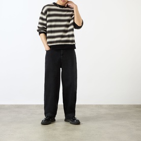 Model wearing Emporium Stripe Fisherman Knit Sweater in black, heavyweight crew neck with bold stripes, styled with wide-leg black trousers and black
