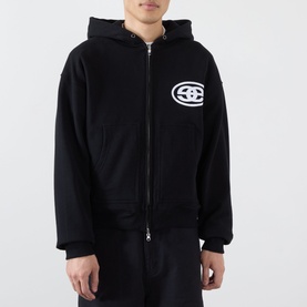 Model wearing Emporium Thermal Logo Hoodie in black, zip-through with embroidered logo, paired with black trousers.