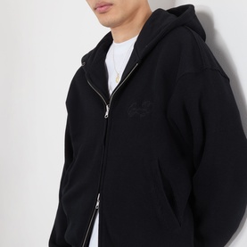 Model wearing Emporium Thermal Logo Hoodie in black, zip-up style with tonal logo embroidery, styled over a white tee