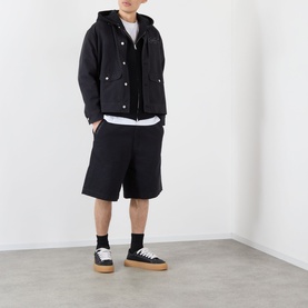 Model wearing Emporium Thermal Logo Hoodie in black with black shorts and black-and-gum sole trainers.