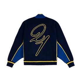 Emporium navy knitwear varsity-style jacket, back view, with gold script logo embroidery and blue panelled sleeves