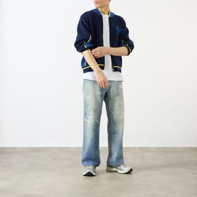 Model wearing Emporium Boca Logo Knitted Zip Sweater in navy, styled with distressed wide-leg jeans and white trainers.