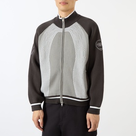 Model wearing Emporium E90 Logo Knitted Zip Sweater in grey, featuring jacquard knit, white stripe detail, funnel collar, and front zip fastening.