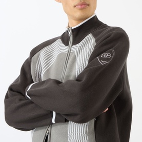 Model wearing Emporium E90 Logo Knitted Zip Sweater in grey, featuring jacquard knit panels, funnel collar, and embroidered sleeve logo, arms crossed.