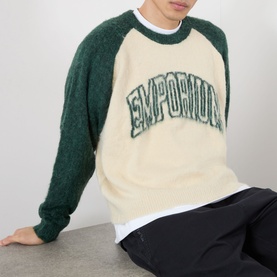 Model wearing Emporium Logo Mohair Sweater in green, cream body with green raglan sleeves, brushed finish, arch logo lettering across chest