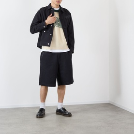 Model wearing Emporium Logo Mohair Sweater in green with black denim jacket, black shorts, white socks and black loafers.
