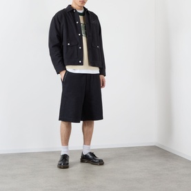 Model wearing Emporium Double-Pocket Shorts in black, knee-length straight-leg fit, styled with a dark jacket and loafers.