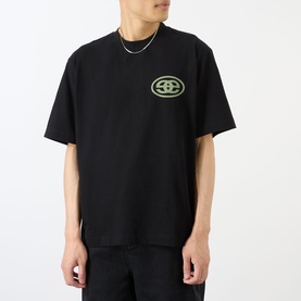 Model wearing Emporium black cotton T-shirt with lime green oval logo graphic on chest, styled with a silver chain necklace.