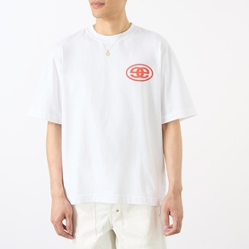 Model wearing Emporium EE Logo T-Shirt in white with red oval chest logo, crew neck, dropped shoulders, paired with white trousers.