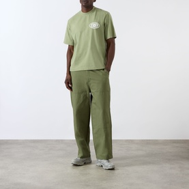 Model wearing Emporium EE Logo T-Shirt in khaki with matching khaki wide-leg trousers and grey chunky trainers.