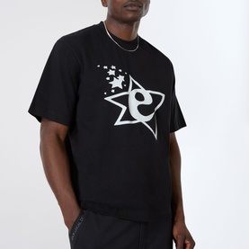 Model wearing Emporium Lucky Stars Logo T-Shirt in black with oversized star and letter graphic print, styled with matching black joggers and chain