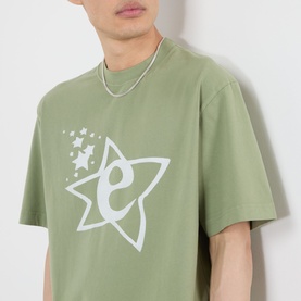 Model wearing Emporium Lucky Stars Logo T-Shirt in khaki green with white star and logo screenprint, styled with a silver chain necklace.