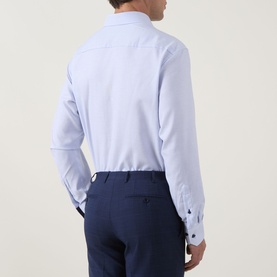 Model wearing Eterna Blue Single Cuff Regular formal shirt, rear view, styled with navy trousers. Navy contrast cuff buttons visible.